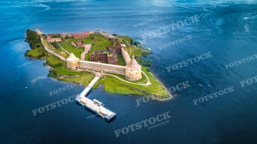 Эта фотография демонстрирует Крепость Орешек, расположенную на острове в устье реки Невы. Это историческое место известно своим значением в обороне и истории России. Снимок сделан с воздуха, и крепость выглядит как уединенный островок истории среди водного простора. Фото подойдёт для использования в исторических исследованиях, учебных пособиях, туристических проспектах и культурных публикациях.